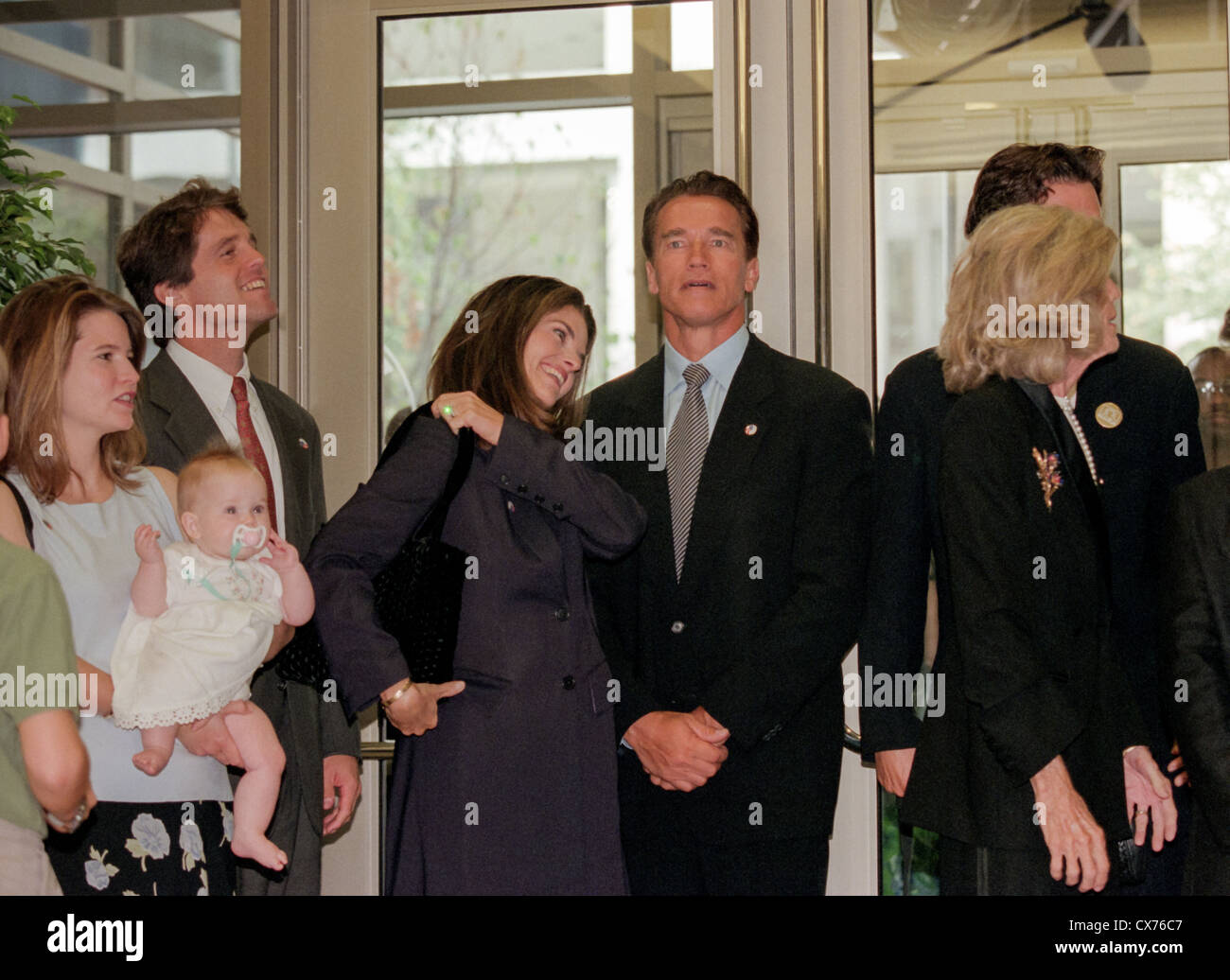 Members of the Shriver family attend the dedication of the new Peace Corps headquarters September 15, 1998 in Washington, DC. (L to R) Jeanne Shriver, holding six-month-old daughter Molly, Jeanne's husband Mark Shriver, Maria Shriver, Arnold Schwarzenegger and Eunice Shriver. Stock Photo