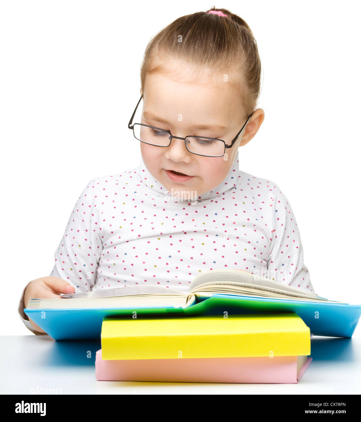 Cute little girl reading book wearing glasses, isolated over white
