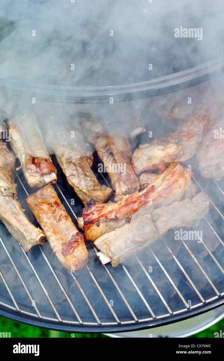 Barbecue Pork Ribs in a small portable barbeque Stock Photo