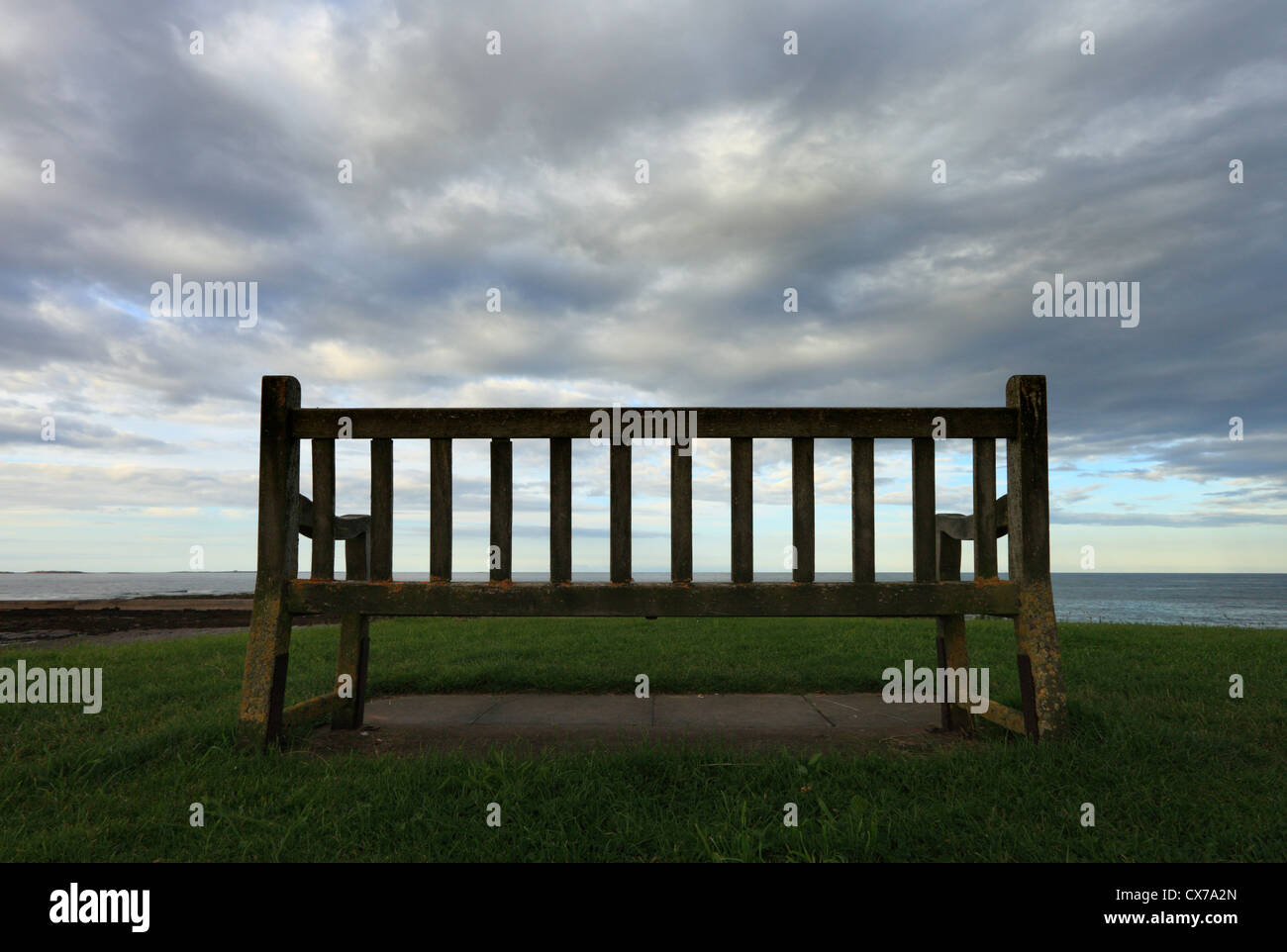 A lonely, empty bench overlooking the North Sea at Seahouses on the Northumberland coast. Stock Photo