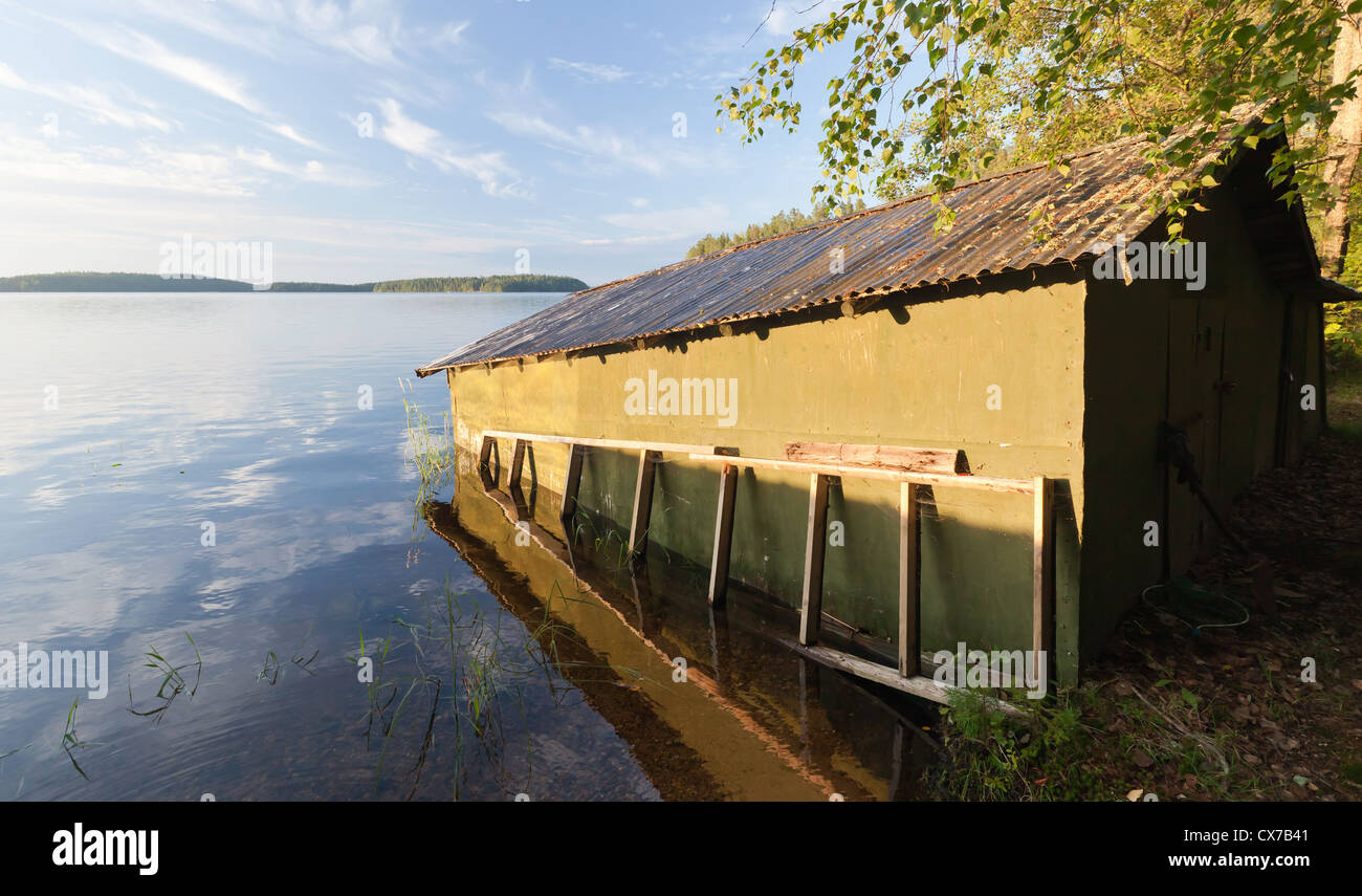 Small green wooden boat garage on the coast of Saimaa lake, typically construction for Finland Stock Photo