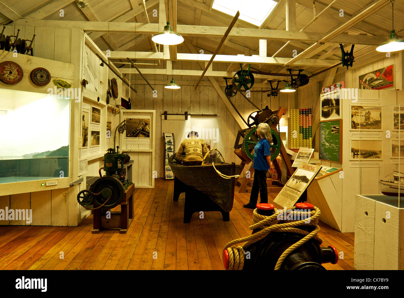 Female visitor examining commercial salmon fishing & cannery exhibit Museum at Campbell River BC Canada Stock Photo