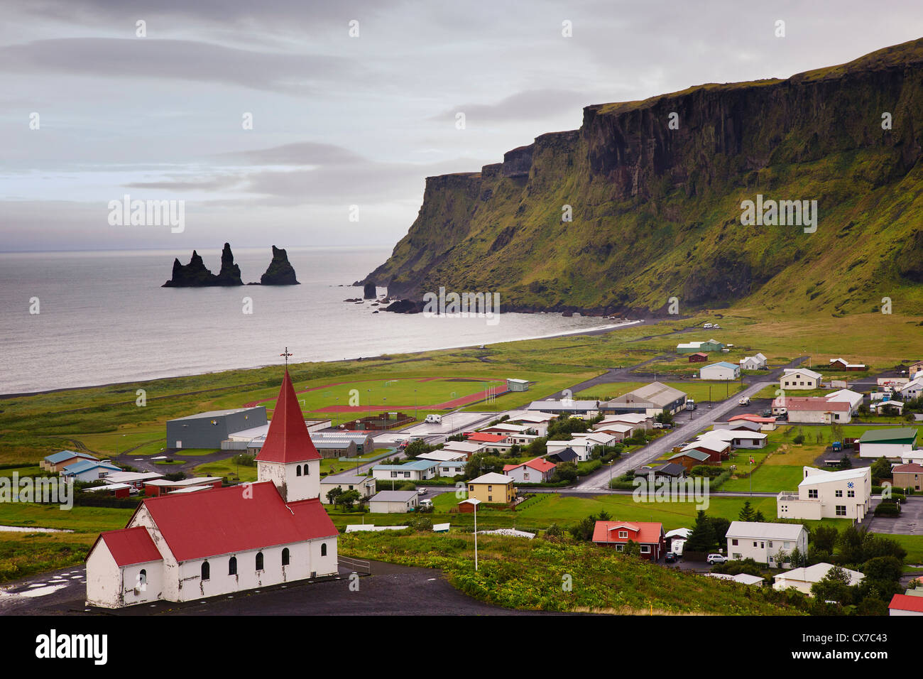 Aerial view over Vik (vik i myrdal) with its church and the reynisdrangar (basalt sea stacks) at dawn, South Iceland Stock Photo