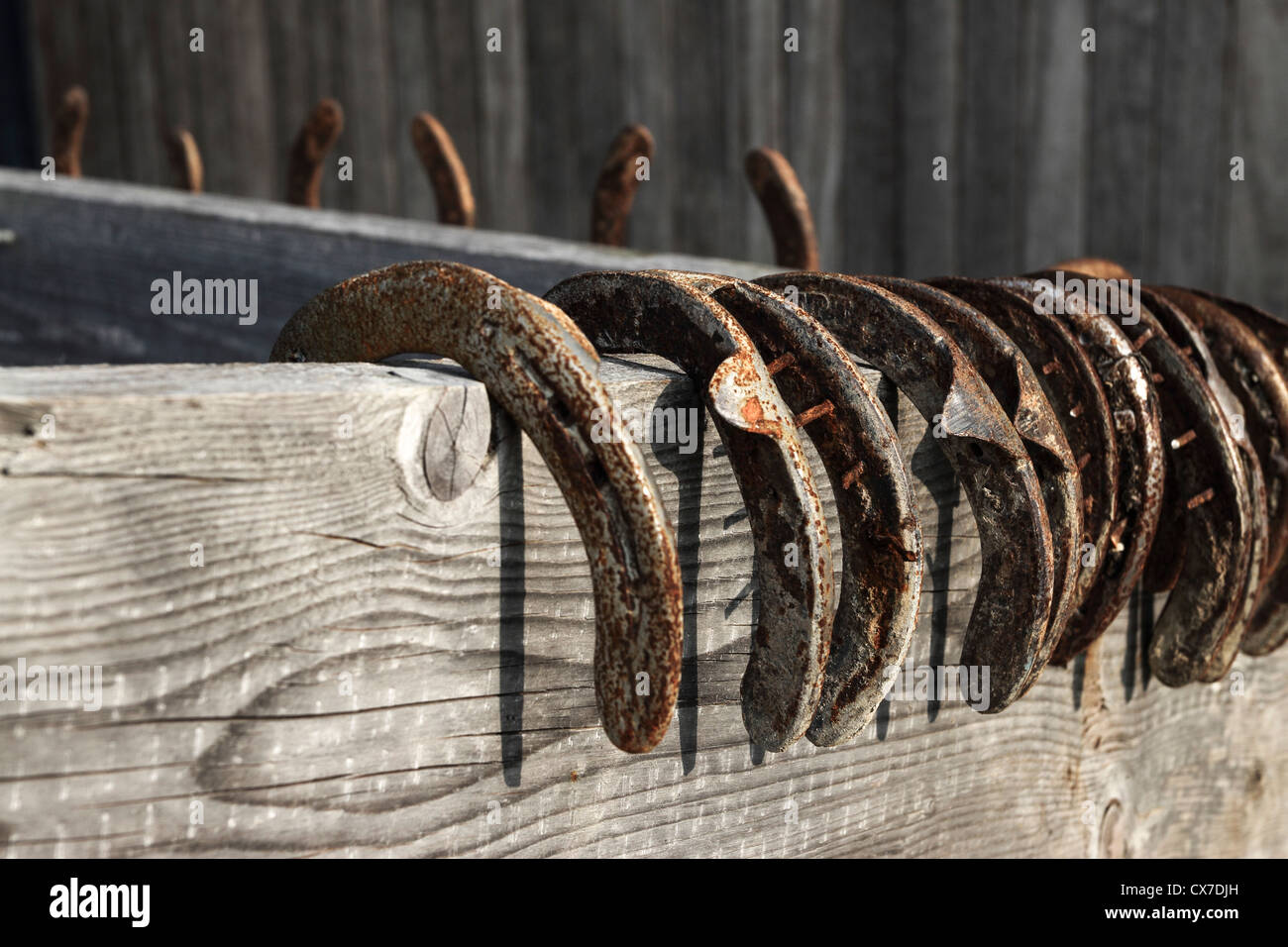 Horse shoes hang from a wood fence Stock Photo - Alamy
