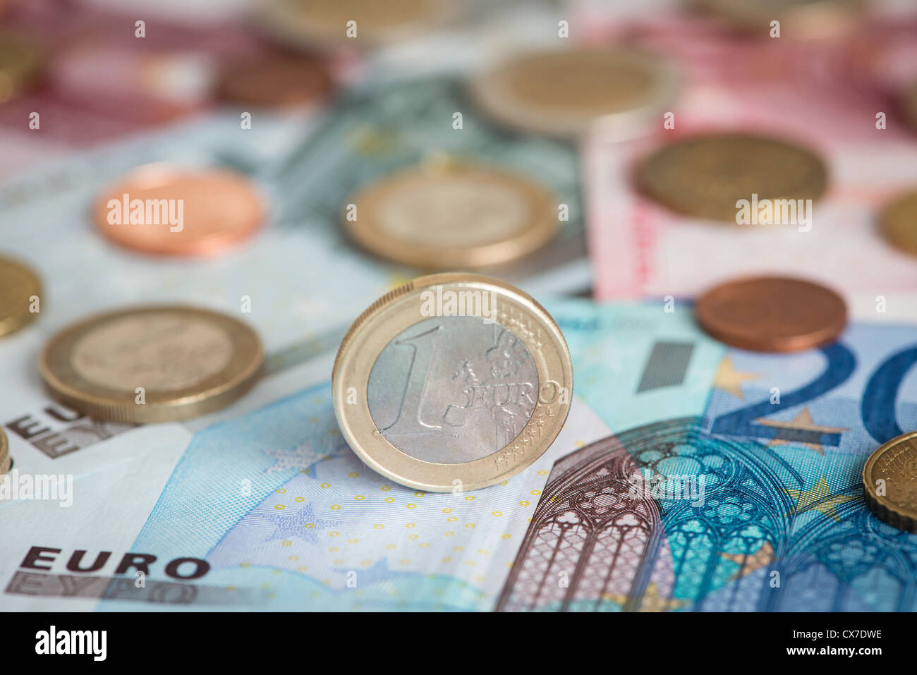 one euro coin standing on euro note Stock Photo
