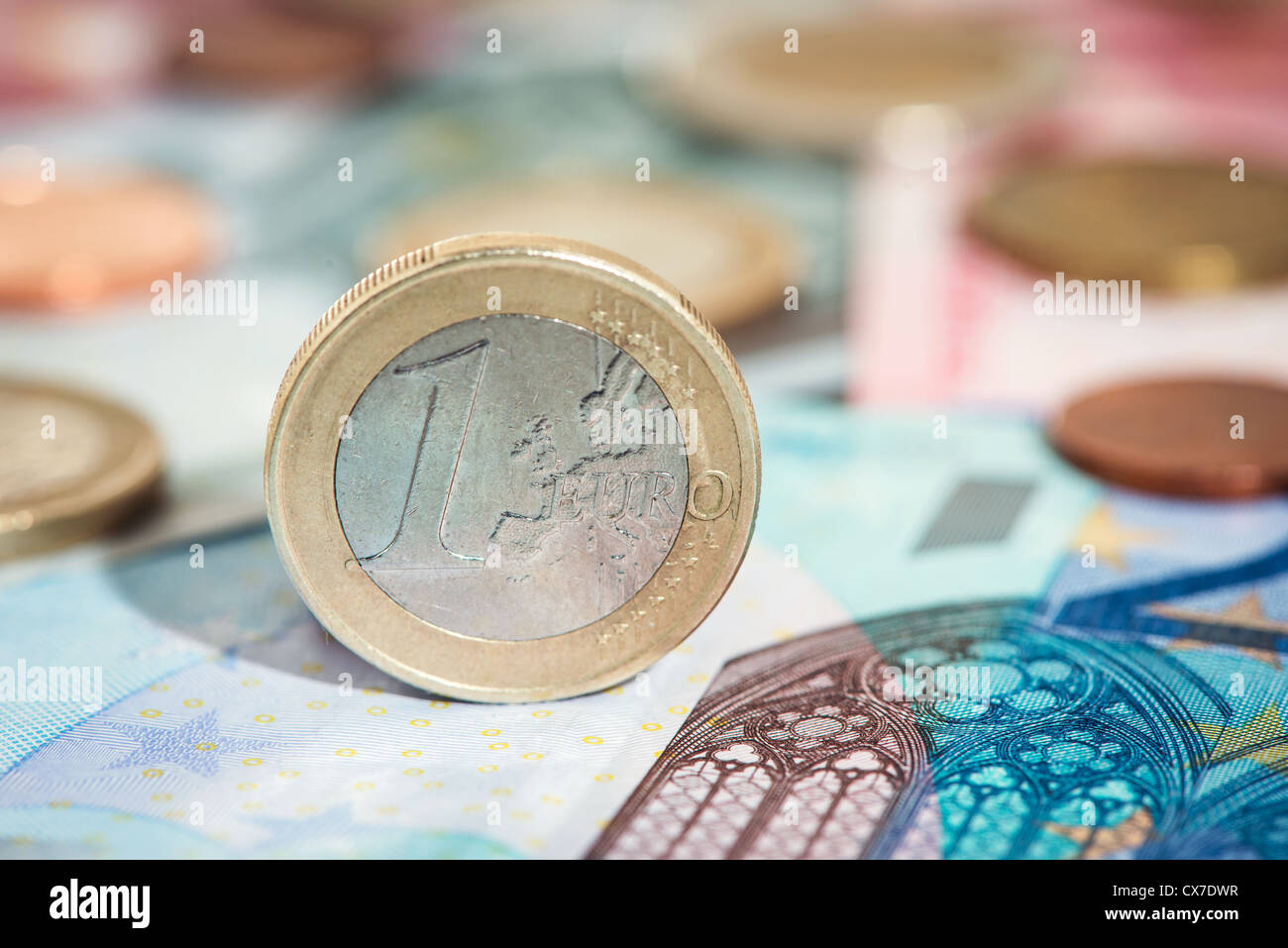 Detail of one euro coin standing on euro note Stock Photo
