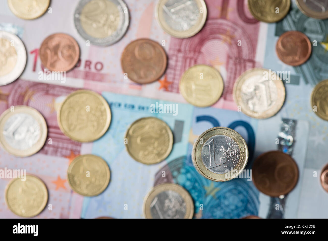 detail of one euro coin, other coins and notes in background Stock Photo