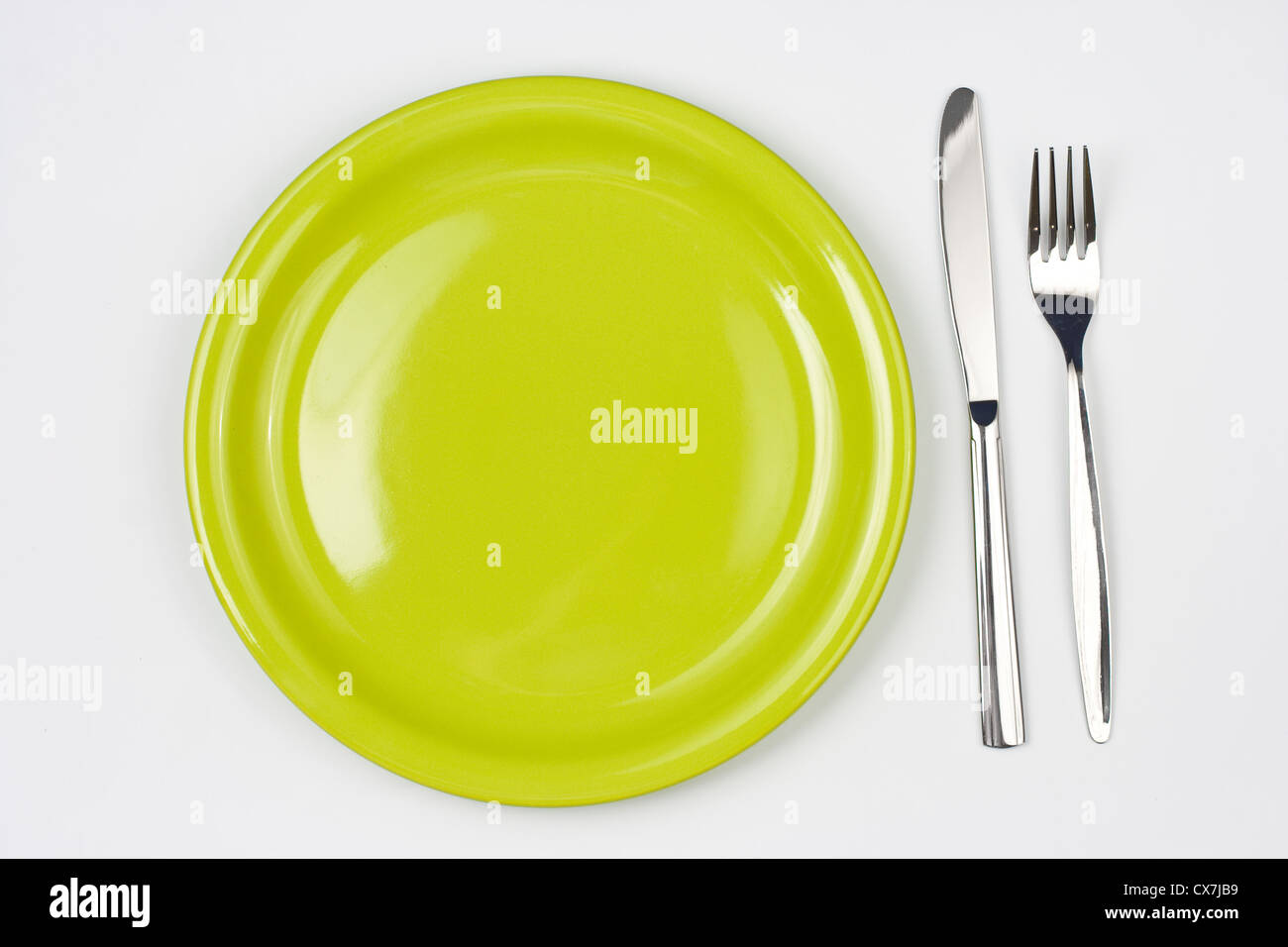 Knife, green plate and fork Stock Photo