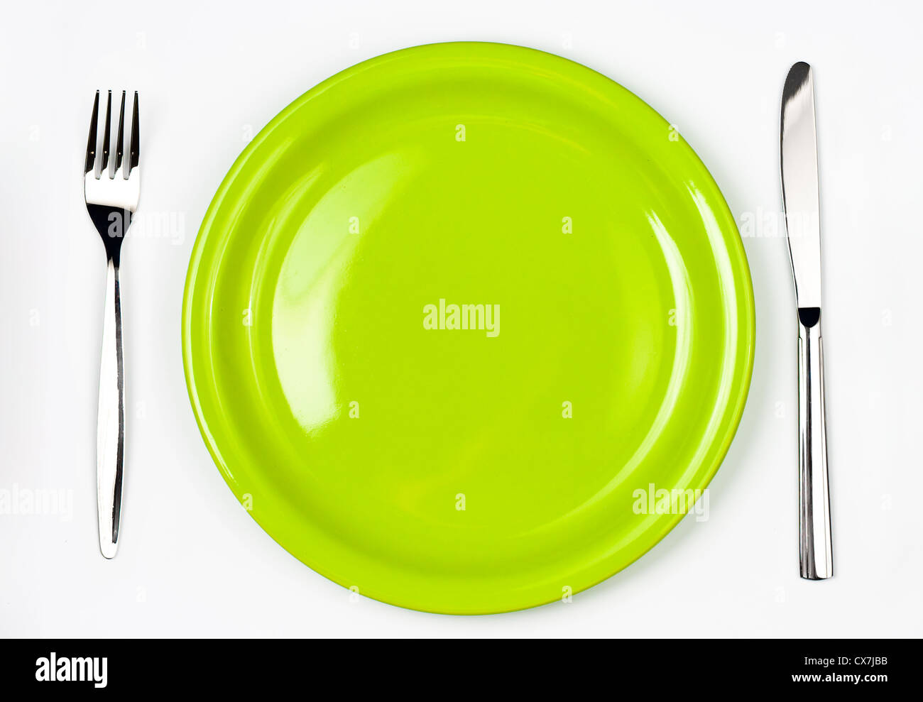 Knife, green plate and fork Stock Photo