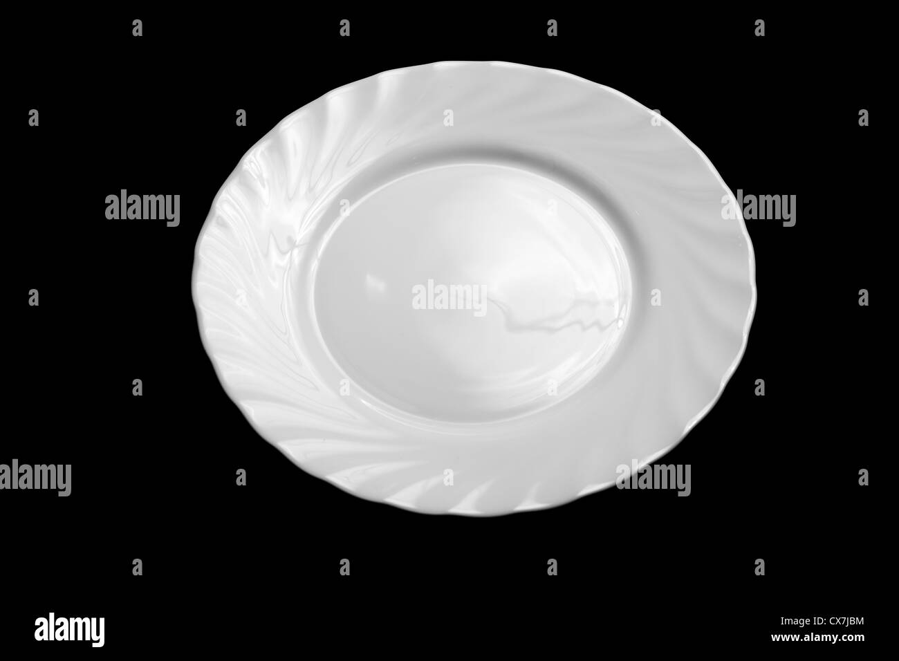 Round white plate isolated on black background Stock Photo