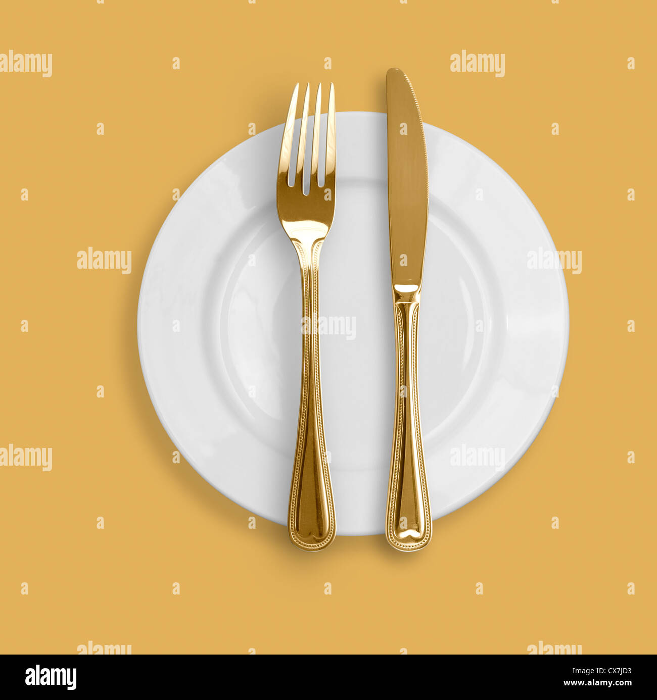 Knife, plate and fork on beige background Stock Photo