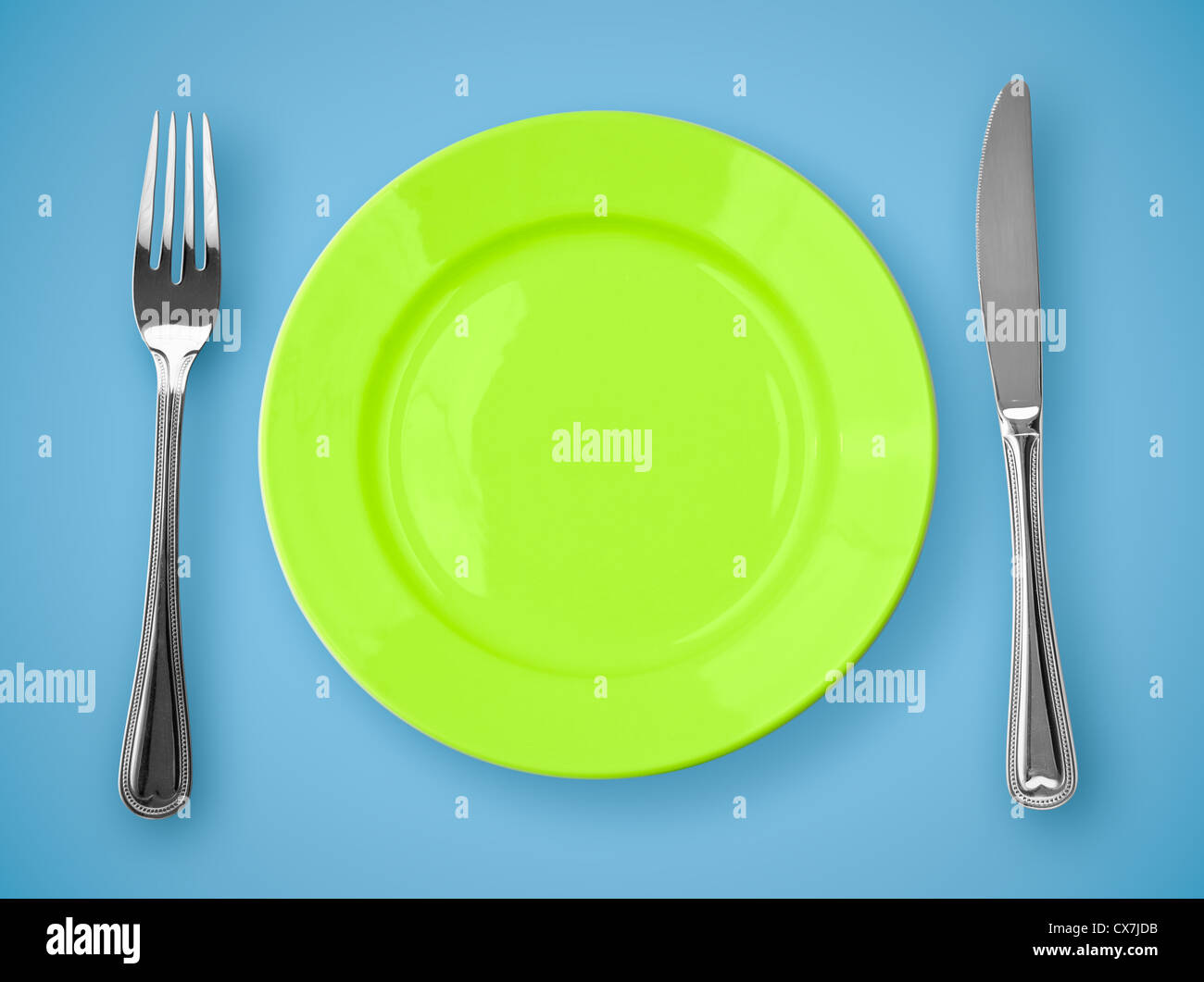 Knife, green plate and fork Stock Photo