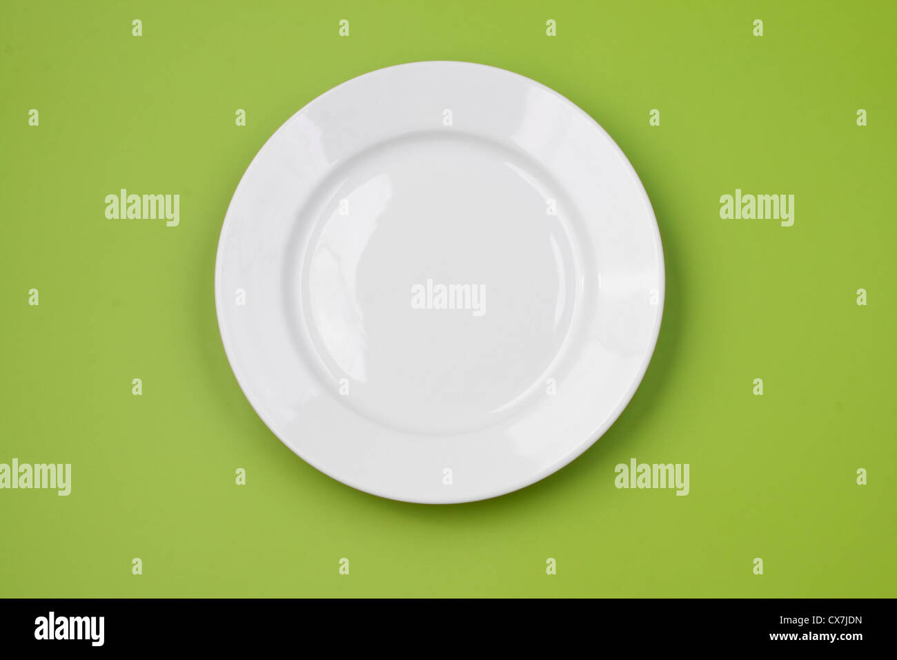 White round plate on green background Stock Photo