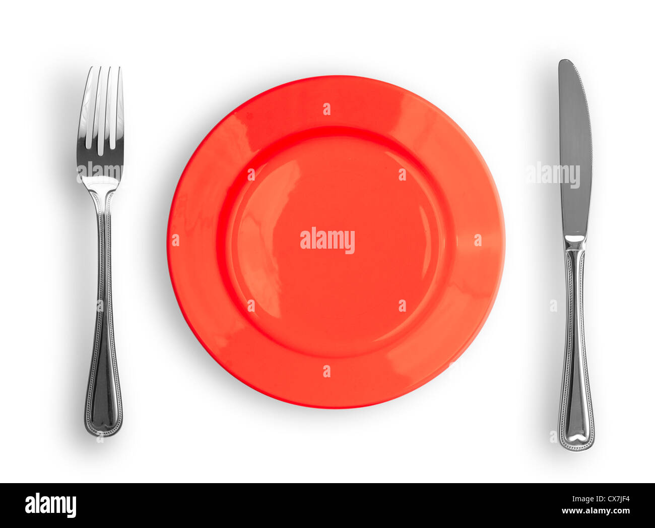 Knife, red plate and fork isolated Stock Photo