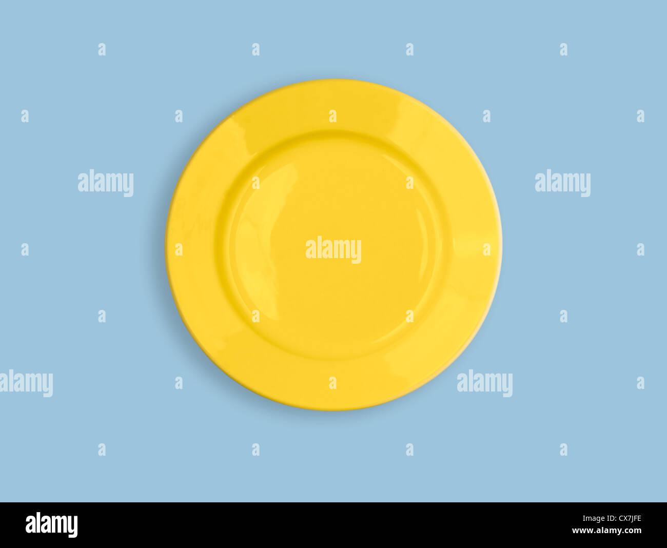 Yellow round plate on sky blue background Stock Photo