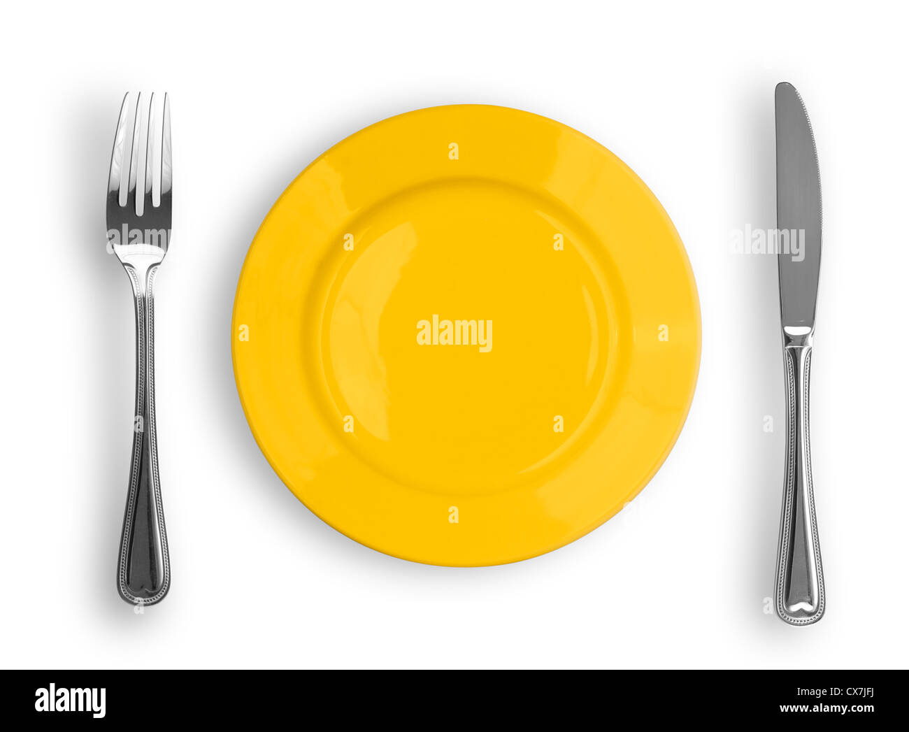 Knife, yellow plate and fork isolated Stock Photo