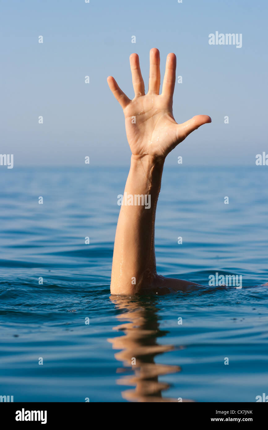 single hand of drowning man in sea asking for help Stock Photo