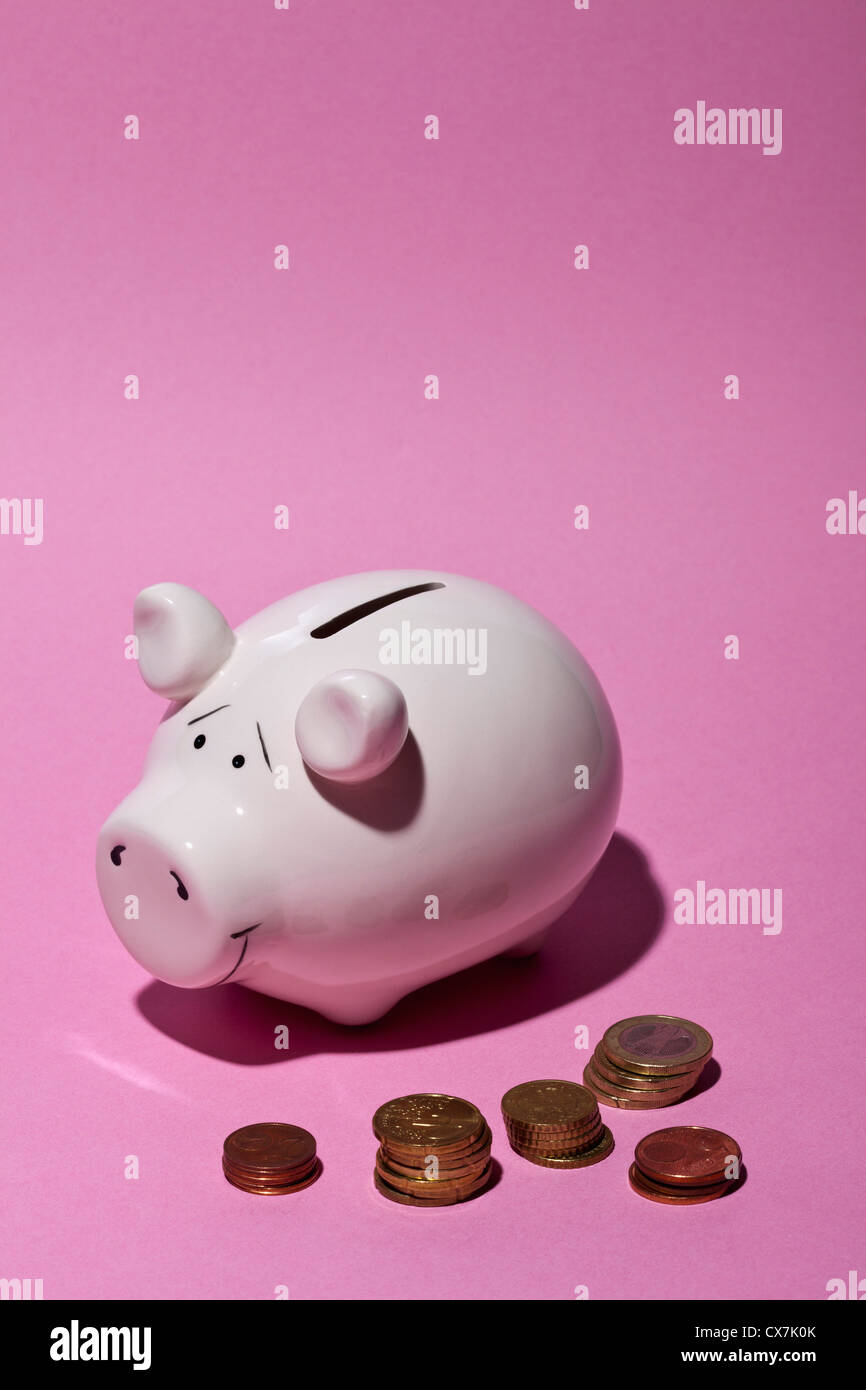 A piggy bank and stacks of European Union coins Stock Photo