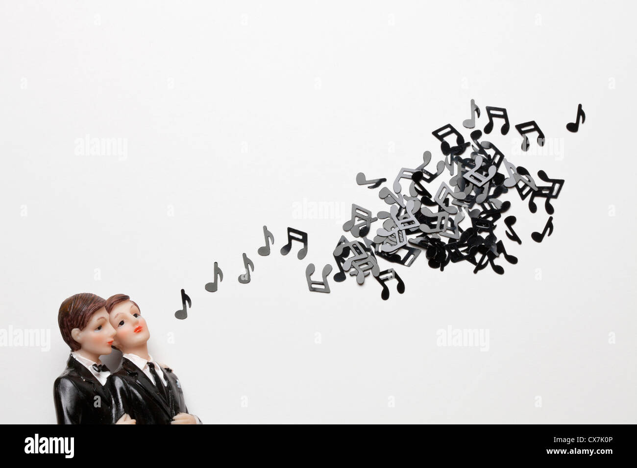 Two male figurines next to a group of musical notes Stock Photo