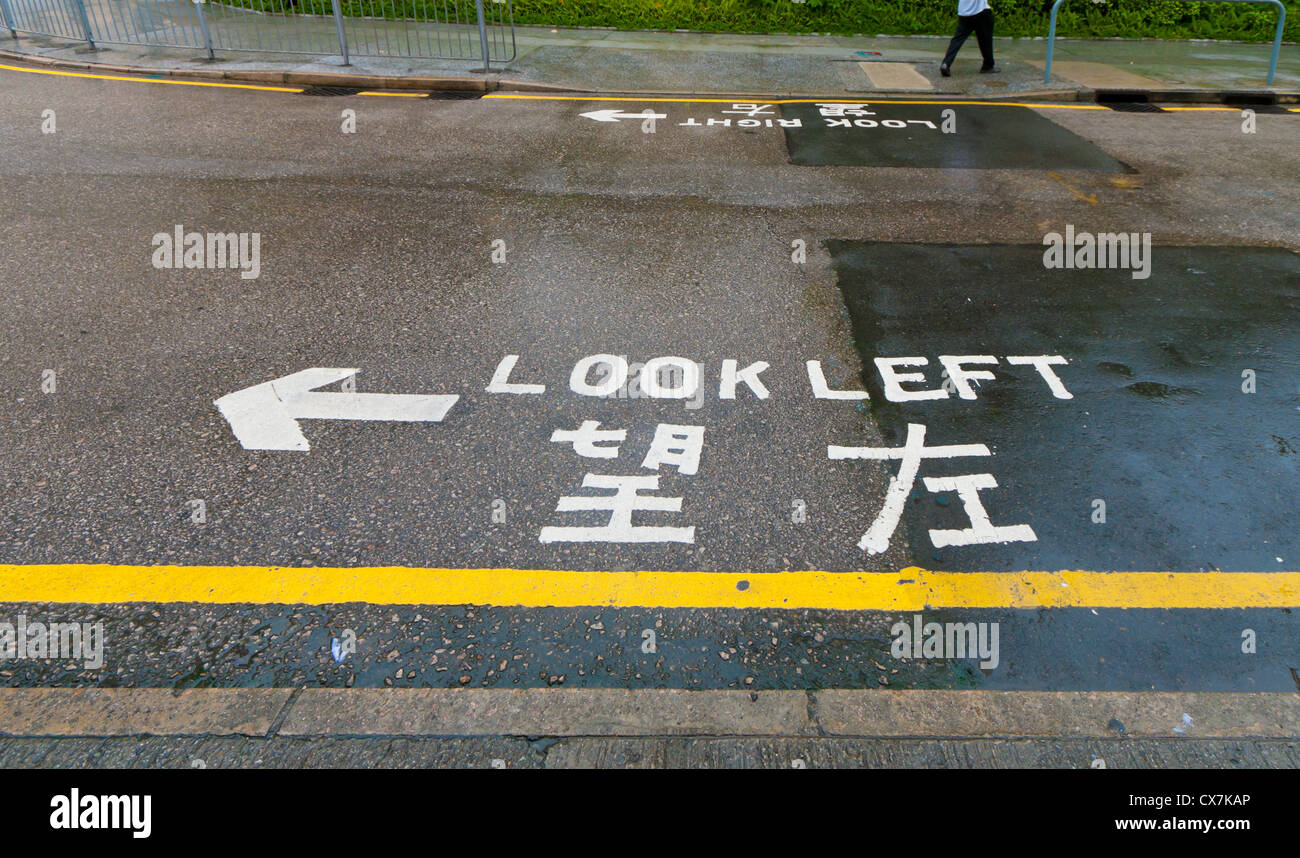 "look left" sign on a street in hong kong, advising safety for