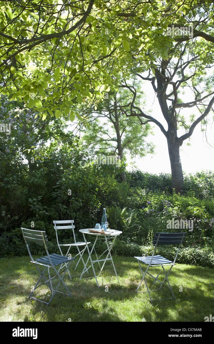 A table and chairs set up under the shade of a tree Stock Photo