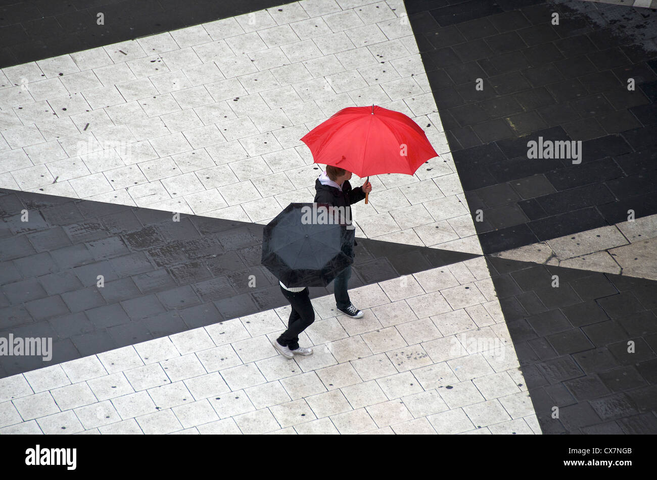 Two pedestrians with umbrellas Stock Photo - Alamy