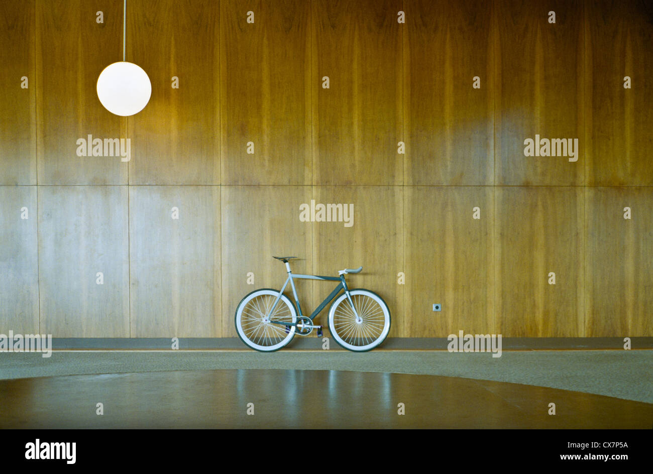 Bike parked against wood paneling Stock Photo