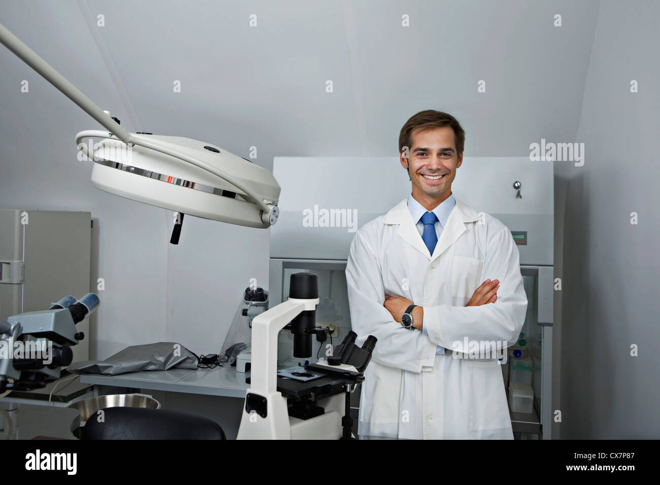 A cheerful research technician standing in a research lab, arms crossed Stock Photo