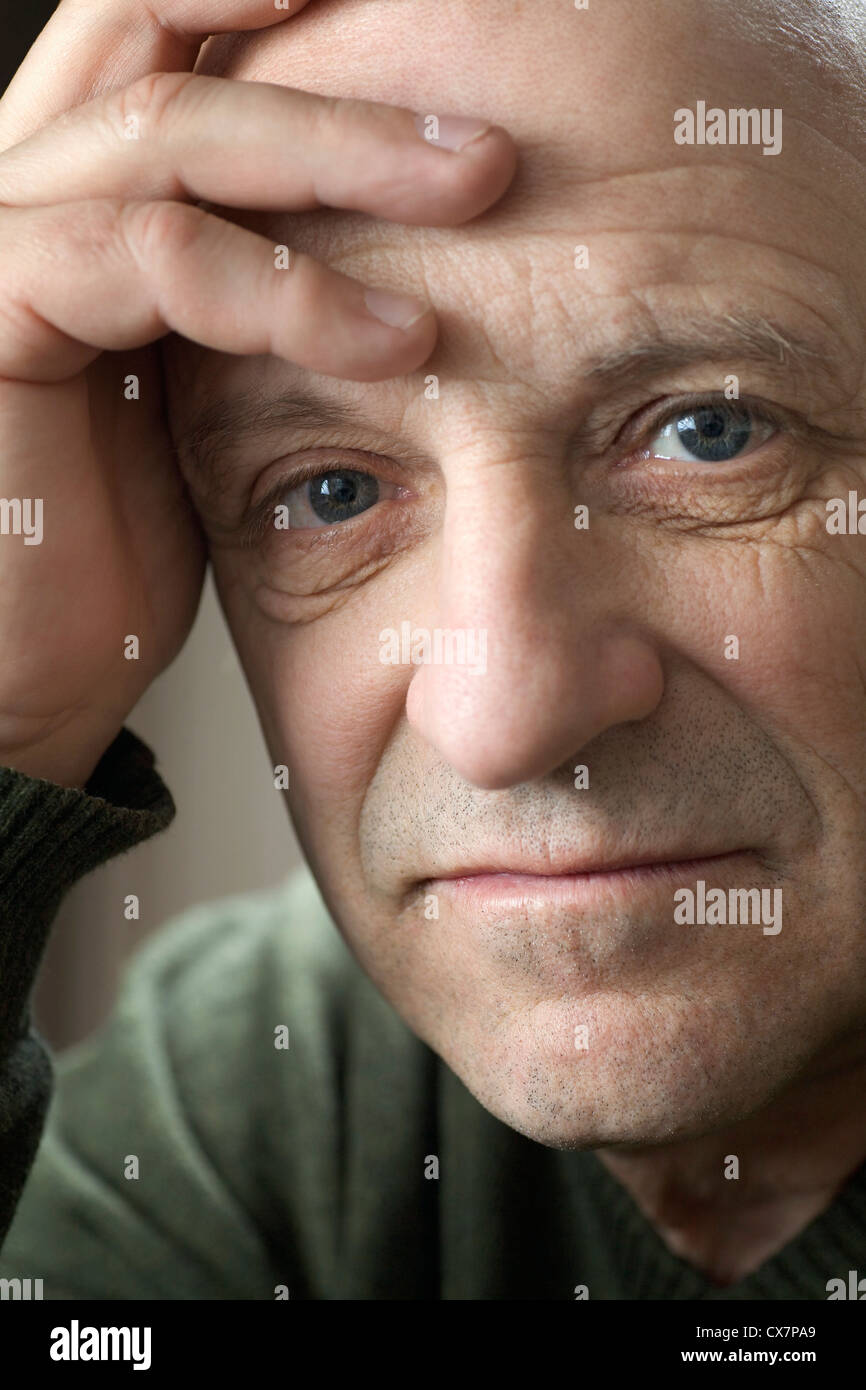 A senior man with his hand on his forehead, close-up Stock Photo