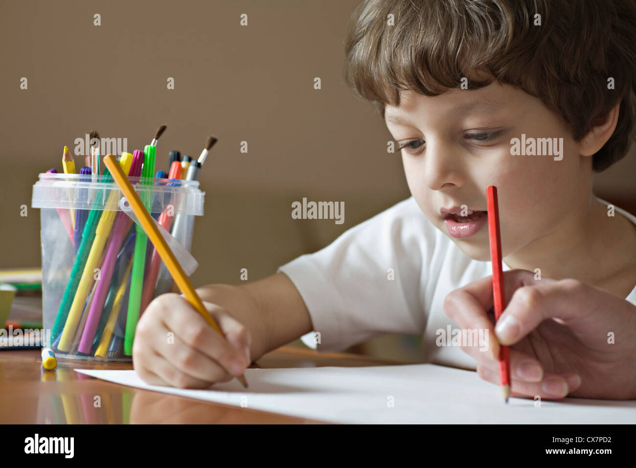 A boy and a friend drawing with colored pencils, viewpoint of boy Stock Photo