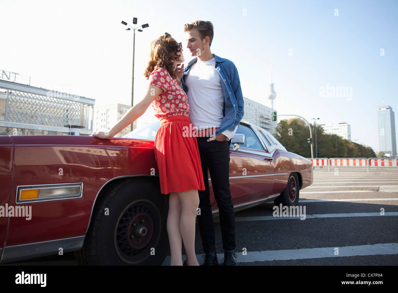 A flirtatious rockabilly couple standing next to a vintage car, Berlin, Germany Stock Photo