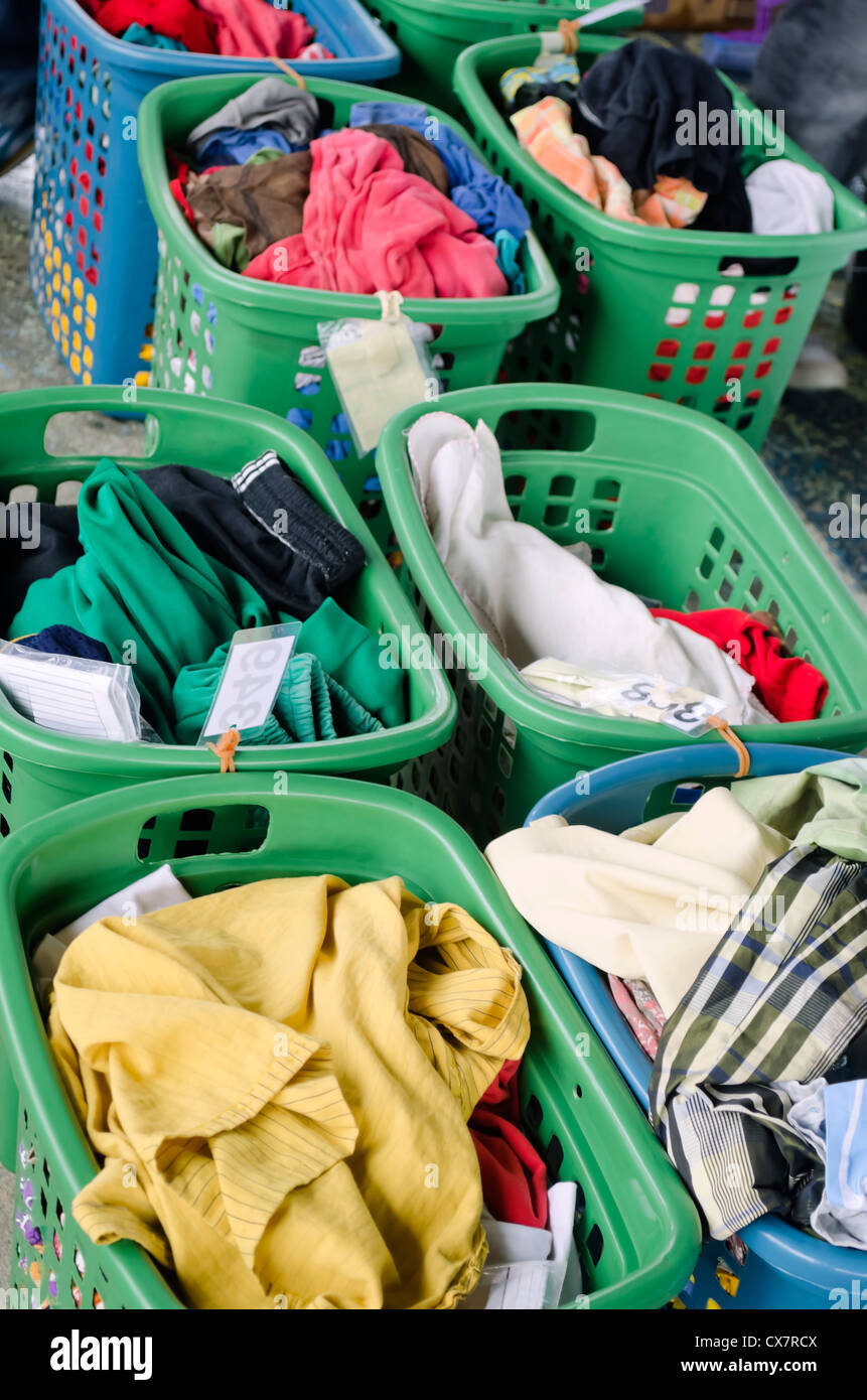 A line of laundry baskets full of dirty clothes for washing Stock Photo