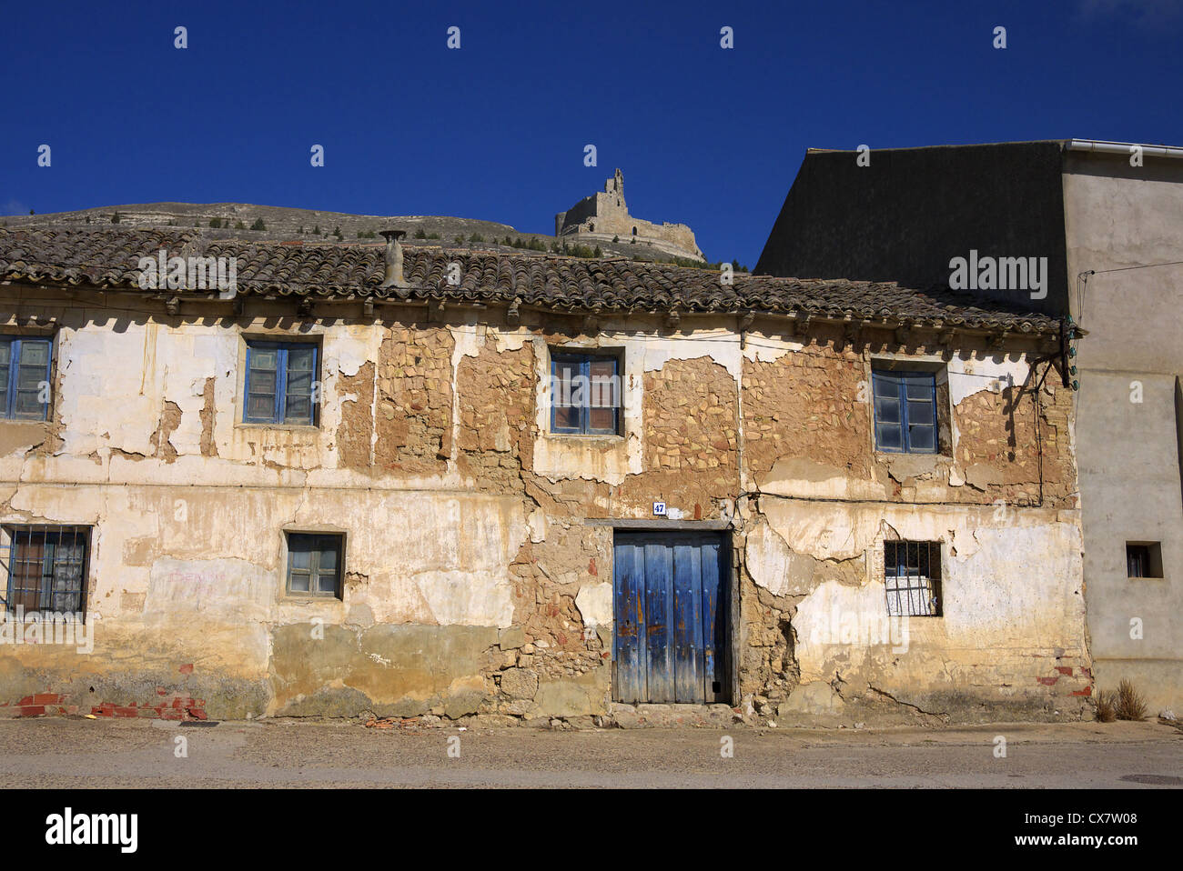 Old buildings in Castrojeriz, Spain, with ruins of the hilltop castle in the background. Stock Photo