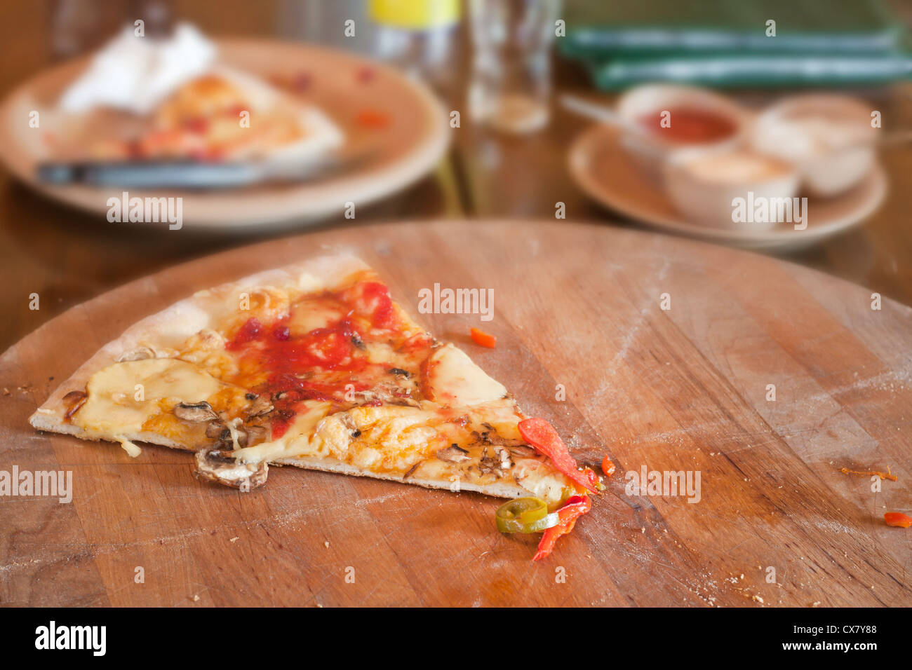 Uneaten piece of pizza in restaurant on the table Stock Photo