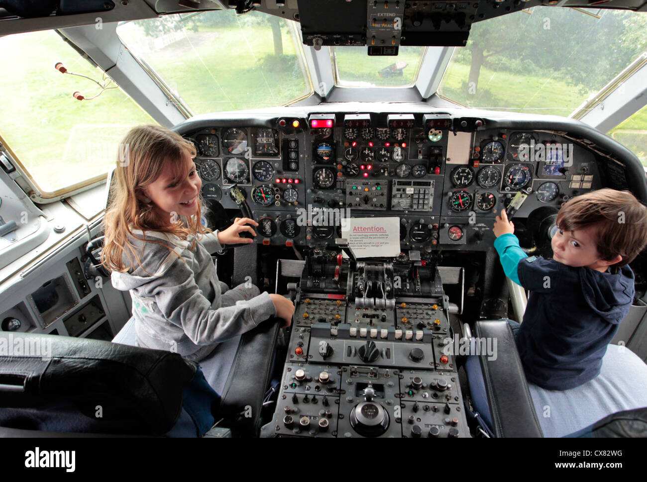 Children sitting at the controls in the cockpit of passenger jet at Brooklands Museum and aerodrome, Weybridge, UK Stock Photo