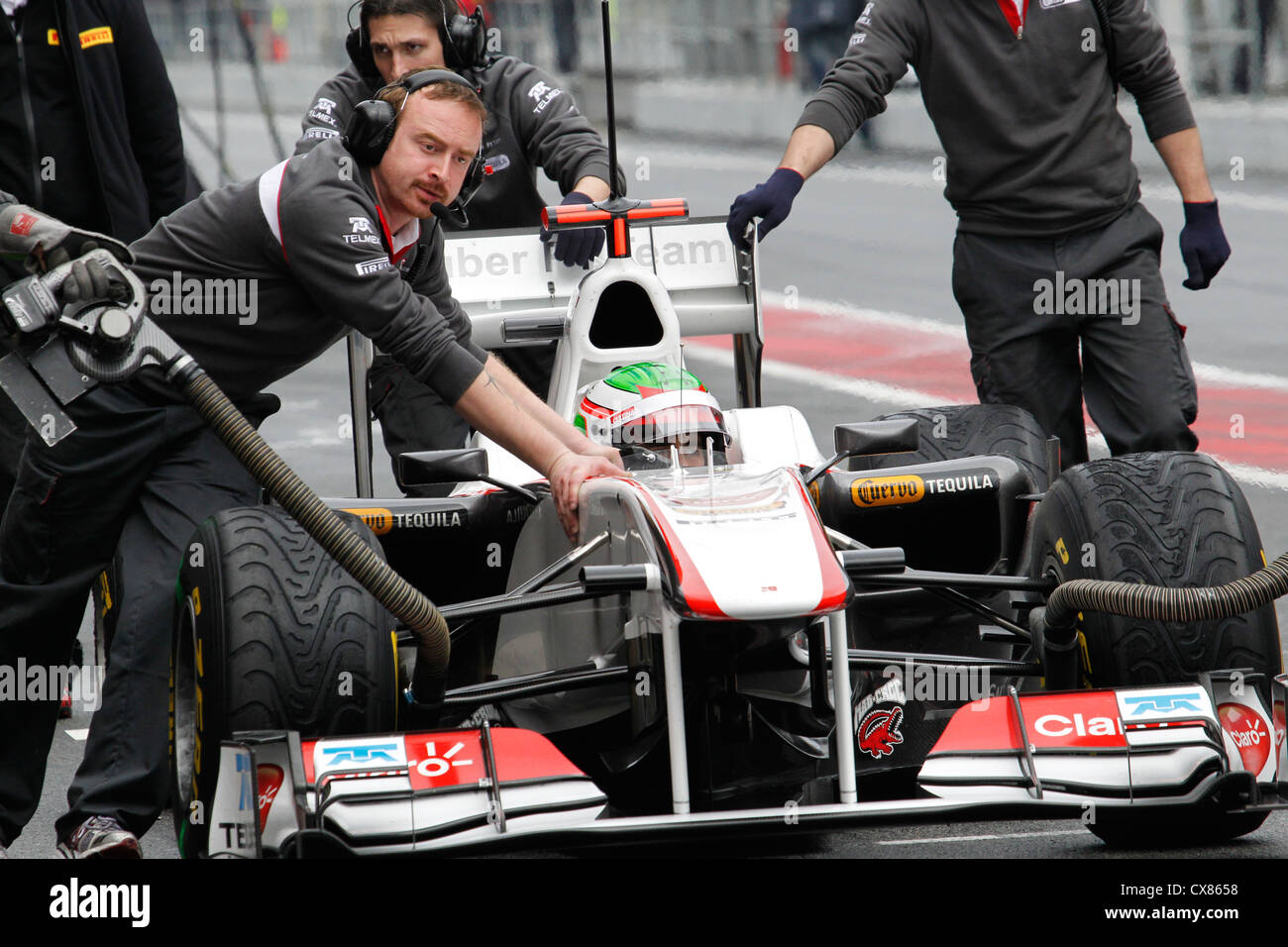 Sergio Perez being pushed by Sauber mechanics at pre-season testing in 2011 at Montmelo racing track in Barcelona, Spain Stock Photo