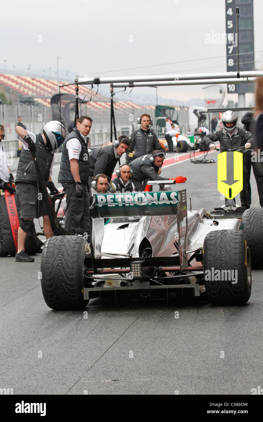 Mercedes GP mechanics carry out pit stop on Nico Rosberg's car during testing at Montmelo racing track in Barcelona, Spain Stock Photo
