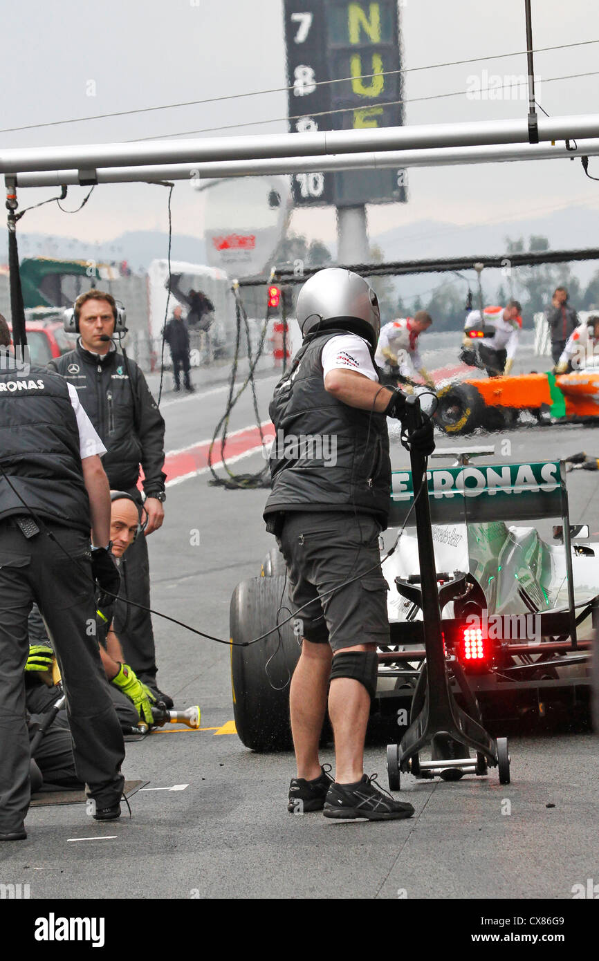 Mercedes GP mechanics carry out pit stop on Nico Rosberg's car during testing at Montmelo racing track in Barcelona, Spain Stock Photo