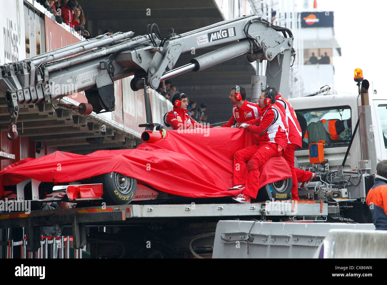 Felippe Massa's Ferrari being lifted into the pit lane after crashing out during Formula One testing at Montmelo, Spain Stock Photo