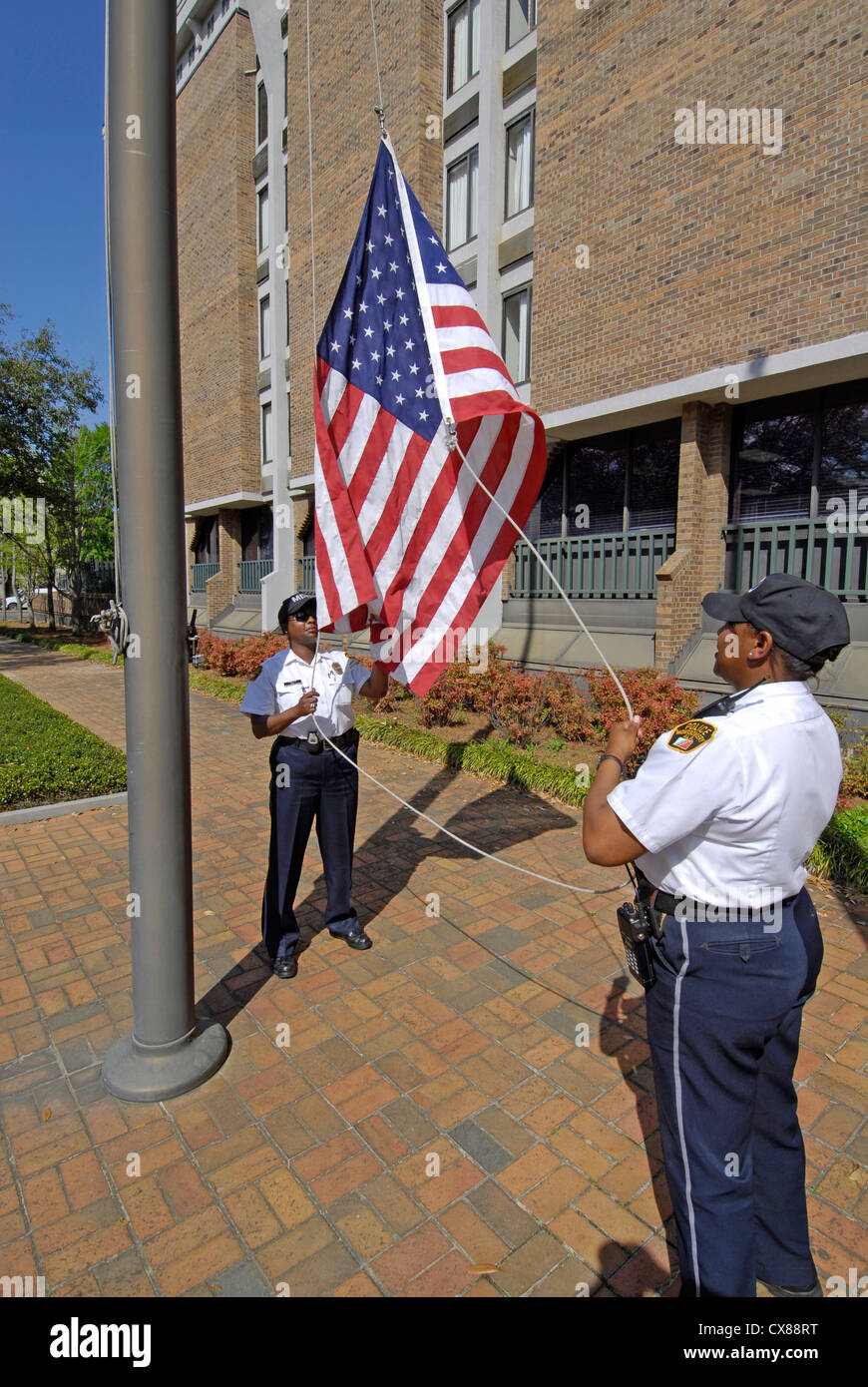 Black male and female police officers take the Americal flag down a