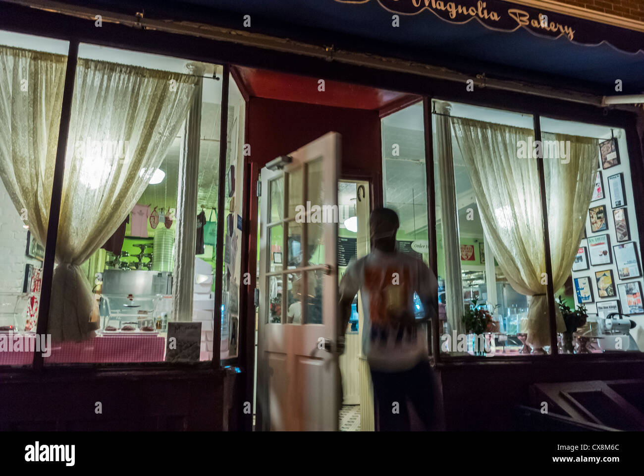 New York City, NY, USA, Shop Front Window at Night, Man Leaving Door, Shopping in Greenwich Village, 'Magnolia Bakery' Small Shop Night Stock Photo