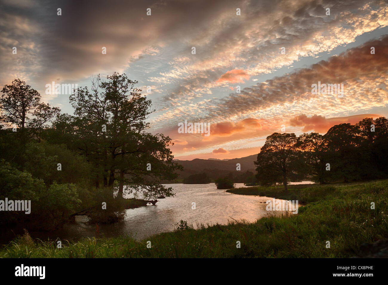 Setting sun illuminates clouds over Rydal Water in English Lake District Stock Photo
