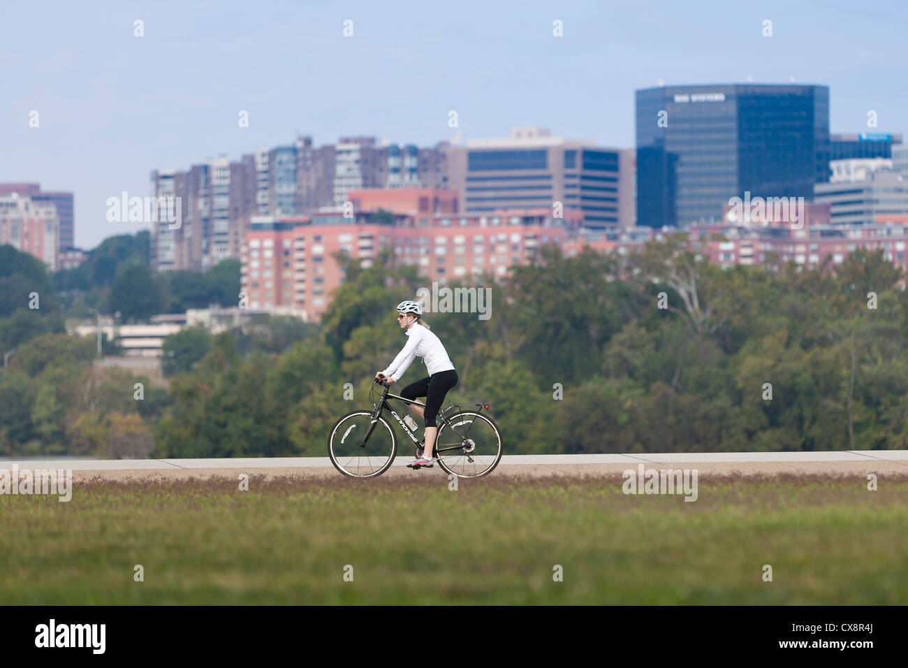 Woman riding a bicycle in urban scenery Stock Photo