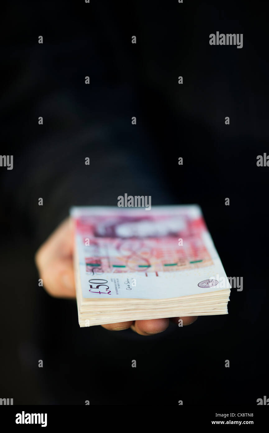 Hand holding Fifty pound notes sterling Stock Photo