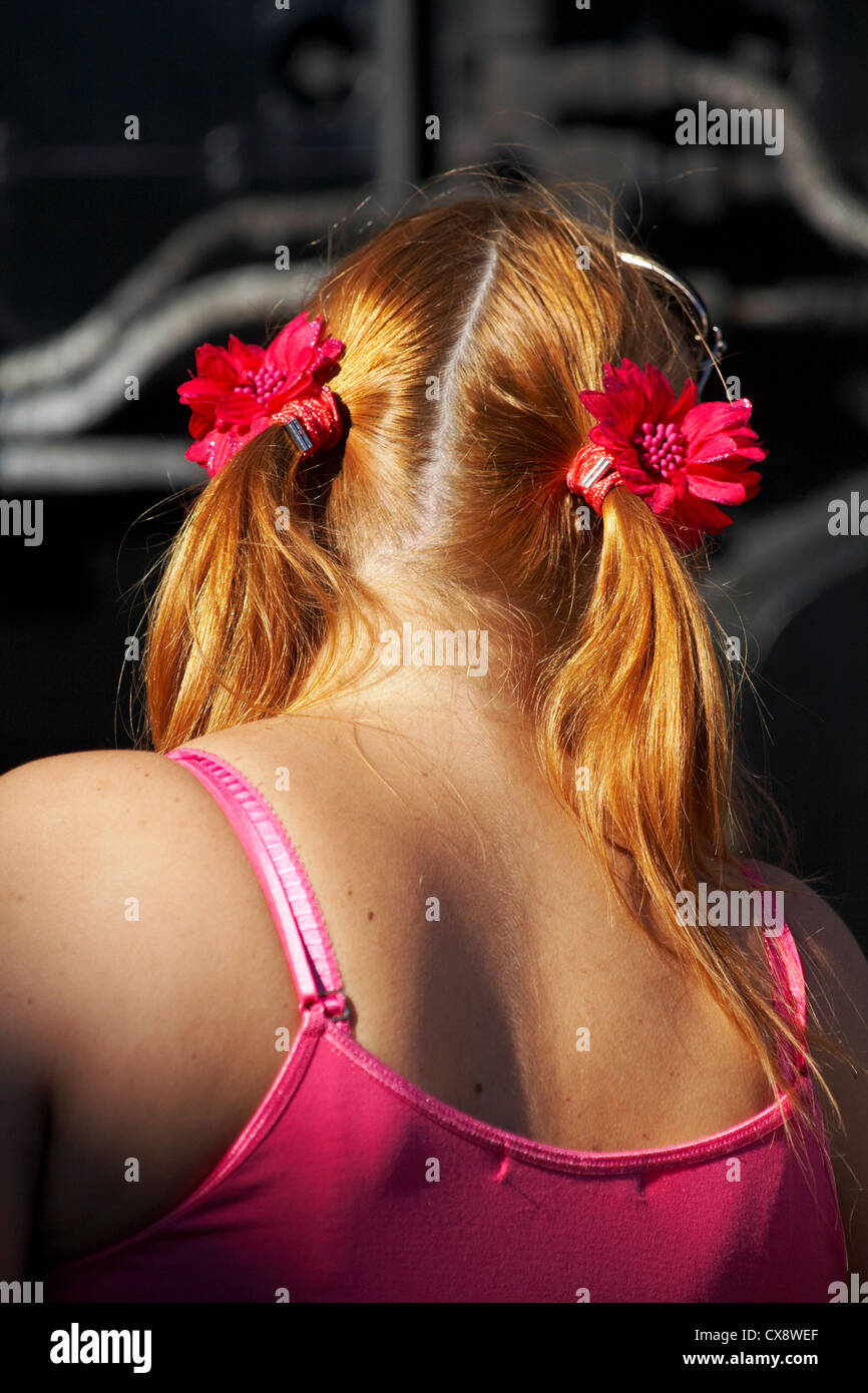 Back view of young woman with ginger hair in pony tails with flower hair bands Stock Photo