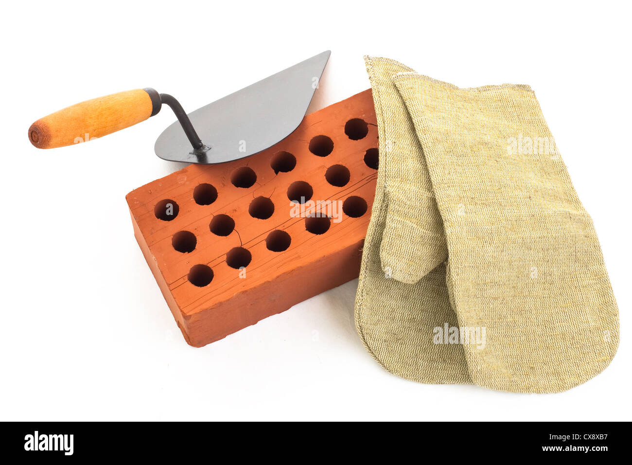 Red perforated ceramic brick, trowel and gauntlet isolated on white Stock Photo