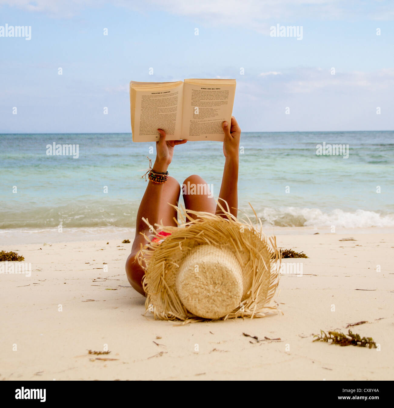 young woman on beach reading book Stock Photo - Alamy