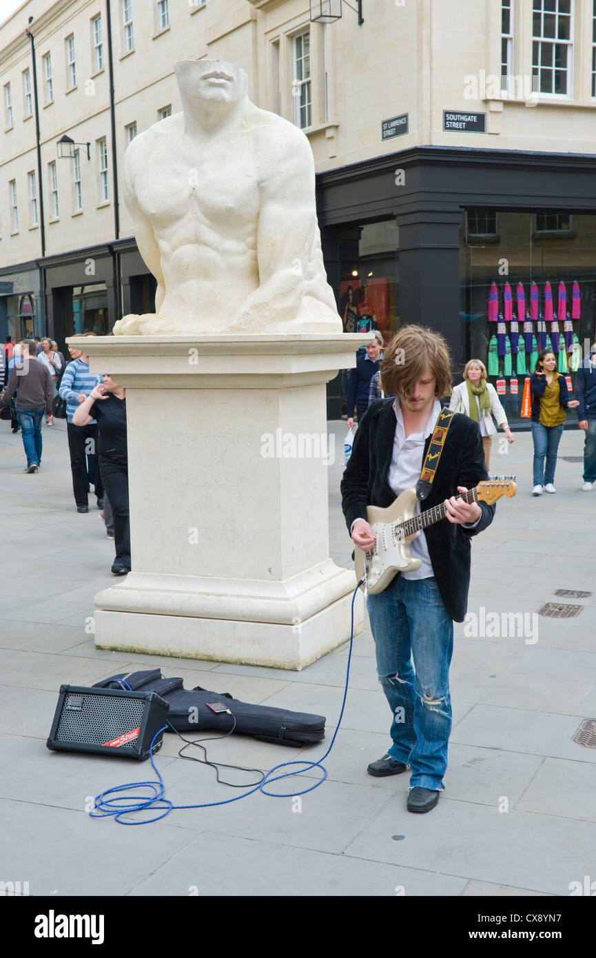 Busker playing electric guitar on pedestrian area in Bath Somerset