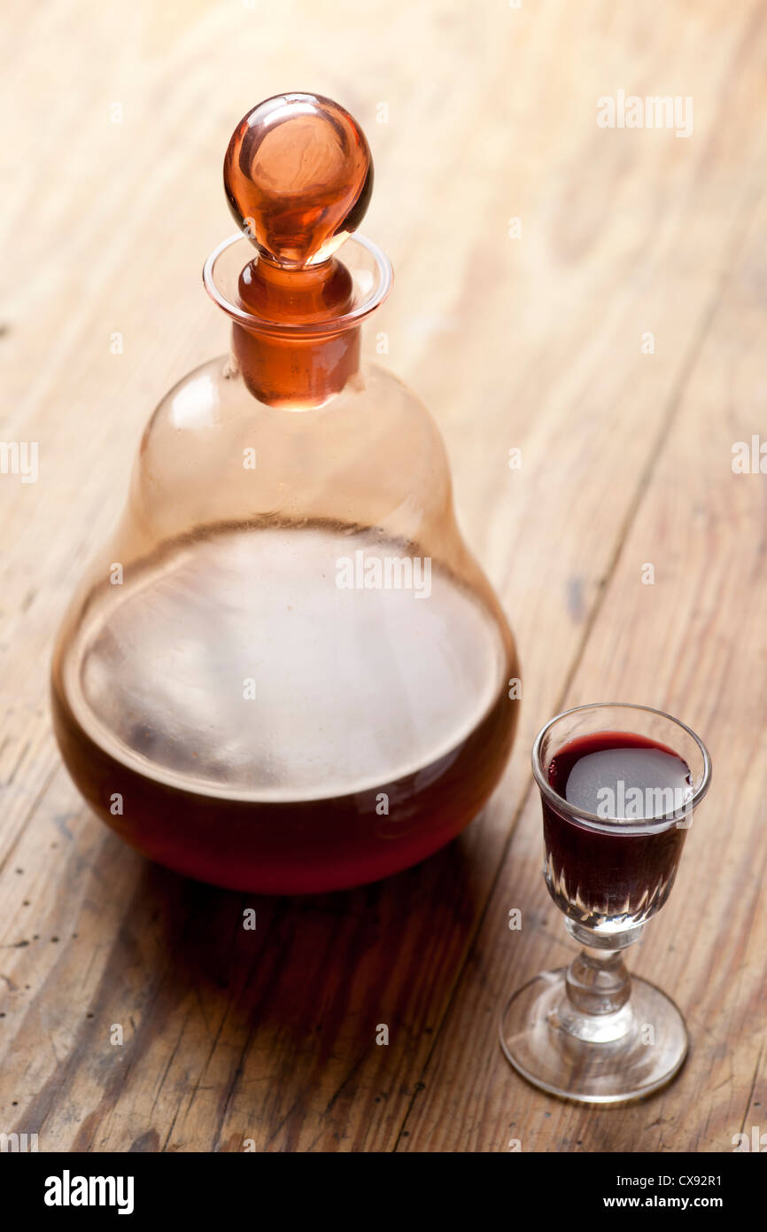 Old antique carafe and glass of liqueur. Traditional Polish aged nalewka. Stock Photo