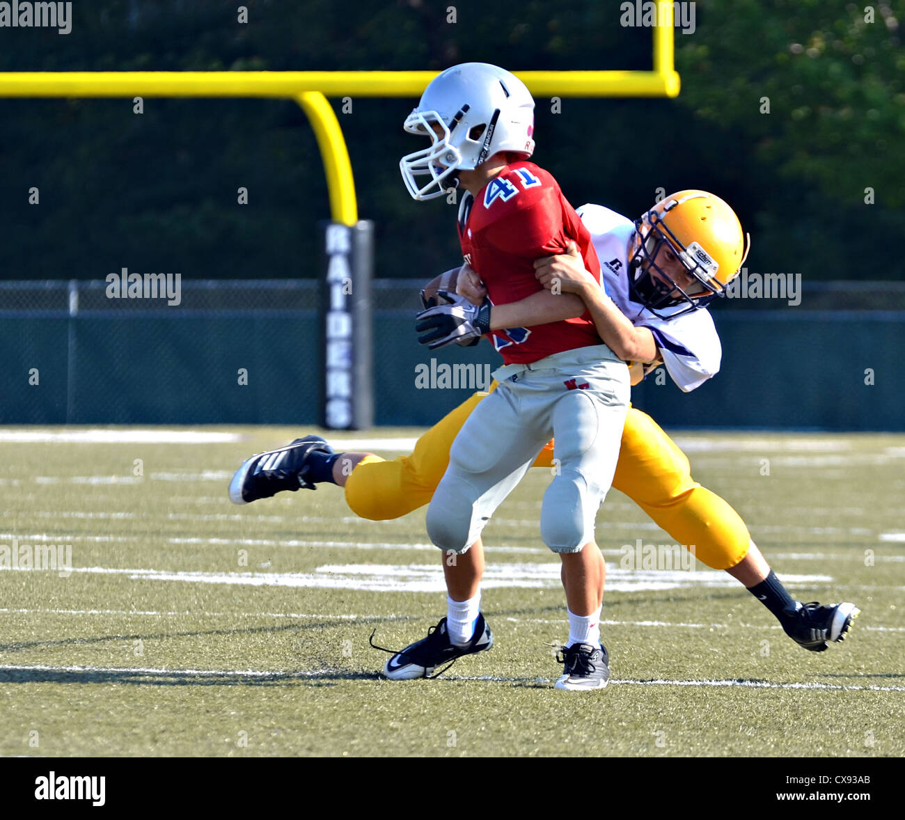 A receiver at the goal line being tackled during a football game of 7th grade boys. Stock Photo